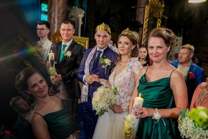 Bridal party stands together during evening celebration with emerald and navy attire.