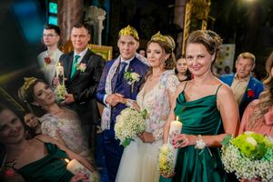 Wedding party members share a candid moment while holding white flower bouquets.