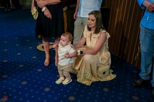 Wedding guests gather in formal attire at an elegantly decorated reception venue.