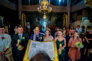 Wedding reception venue decorated with golden chandeliers and ambient blue lighting.