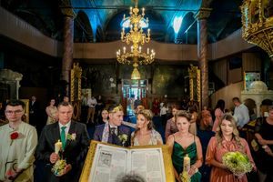 Elegant wedding reception venue features dramatic blue lighting and golden chandeliers.