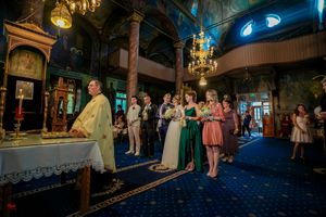Elegant church interior with hanging chandeliers and blue ambient lighting during wedding ceremony.