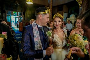 Traditional Orthodox wedding ceremony with priest in embroidered vestments performing sacred rituals.