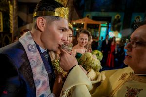 Solemn moment during an Orthodox wedding ceremony with priests in ceremonial dress.