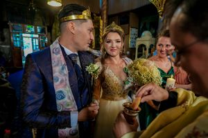 Religious wedding ceremony taking place in an Orthodox church with traditional elements.