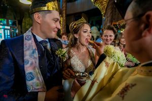 Orthodox wedding ceremony with clergy members wearing elaborate gold vestments.