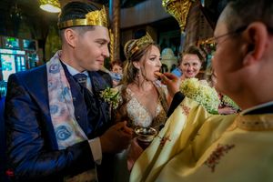 Intimate moment during an Orthodox Christian wedding ceremony with priests in ceremonial attire.