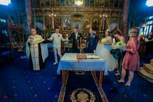 Traditional Orthodox wedding service with decorative iconostasis and chandeliers.