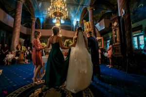 Wide shot of an elegant ballroom reception with guests mingling under crystal chandeliers.