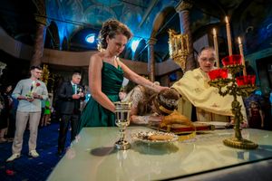Guests serve themselves at an elegant wedding reception dessert table with golden candlesticks.