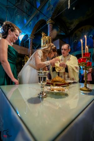 Wedding dinner scene with formal place settings and candlelight in an ornate venue.