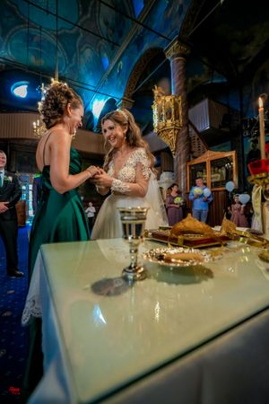 Elegant wedding reception table with white linens and decorative elements under atmospheric blue lighting.