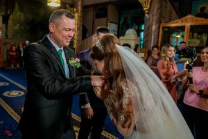 A wedding celebration in an ornate venue with decorative lighting and elegant table settings.