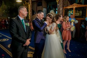Wedding reception guests gather in an elegantly decorated venue with blue lighting.