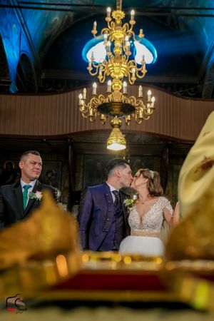 Wedding celebration in a grand ballroom with ornate chandeliers and atmospheric lighting.