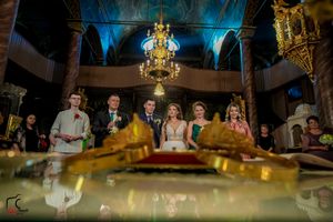 Grand ballroom decorated with gold chandeliers and dramatic blue lighting for an evening celebration.
