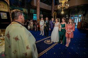 Wedding celebration in progress at an elegant venue with blue carpet and ornate details.
