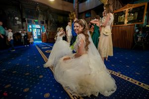 Wedding couple dancing together during their first dance on a blue carpeted dance floor.