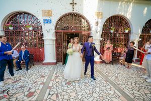 Wedding guests gathered in a beautiful church courtyard with stone patterns.