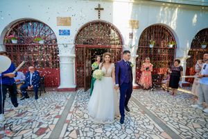 Wedding party celebrating in an elegant church corridor with decorative architecture.