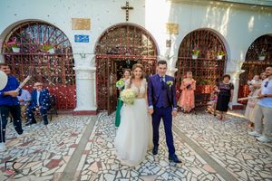 Festive wedding scene with confetti flying in a traditional church courtyard.
