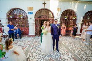 Wedding celebration in a church courtyard with decorative stone flooring and arched doorways.