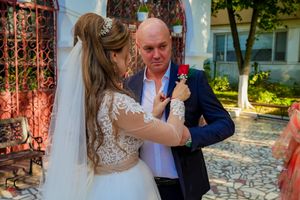 Wedding party dancing and celebrating at an elegant indoor venue with decorative lighting.