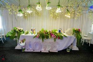 Elegant wedding reception space with white draping and lush floral ceiling installations.