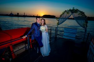 Nautical wedding scene with boat safety equipment and sunset silhouettes.
