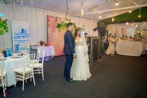 Wedding venue interior with white chairs and decorative greenery hanging from the ceiling.