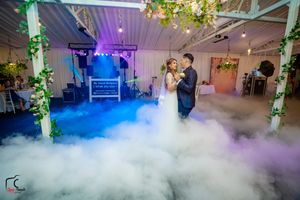 Wedding venue transformed by rolling fog effects and purple mood lighting during a first dance.