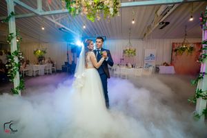 Romantic dance scene with dramatic blue lighting and swirling fog effects in an elegant venue.