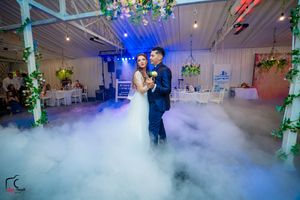Wedding dance captured in a venue with dramatic blue lighting and atmospheric fog effects.