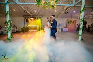 Couple dancing in a dreamy atmosphere with colorful lighting and low-lying fog effects.