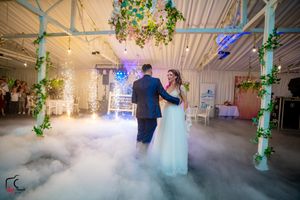 Dreamy wedding scene with low-lying fog and green botanical decor creating magical atmosphere.