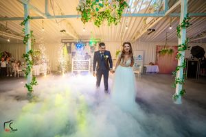 Wedding dance floor transformed by rolling fog and colored lighting creating magical ambiance.