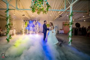Romantic dance scene with blue and white fog swirling around couple on illuminated dance floor.