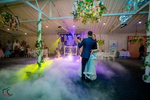 Indoor wedding venue with dramatic lighting and fog effects creating ethereal atmosphere.