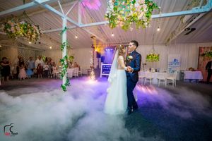 Atmospheric wedding venue with low-lying fog and multicolored lighting creating a dreamy ambiance.