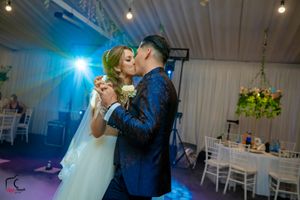 Wedding reception dance floor scene with turquoise lighting and atmospheric fog effects.