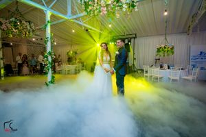 Wedding venue filled with low-lying fog and dramatic yellow-green lighting effects during reception.