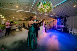 Wedding reception dancefloor filled with ethereal fog and vibrant blue lighting effects.
