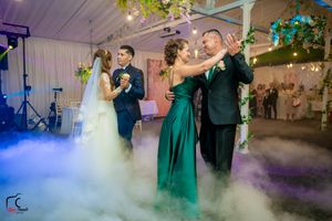 Elegant wedding reception venue with hanging greenery and romantic lighting effects creating a dreamy atmosphere.