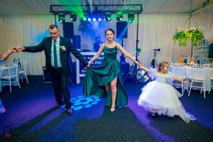 Event participants performing synchronized dance moves under dramatic stage lighting and effects.