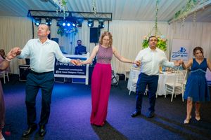 A dance moment at a wedding reception with decorative hanging greenery and elegant table settings.