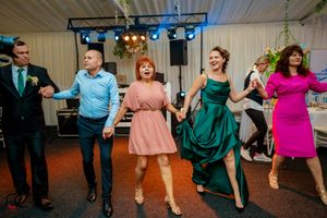 Lively dance sequence at an indoor event with blue flooring and theatrical lighting setup.