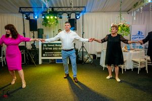 Festive dance routine being performed in an indoor venue with blue floor and ambient lighting.