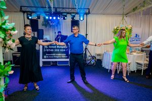 Dance floor scene with multiple couples dancing under blue theatrical lighting.