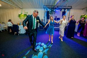 Party guests performing coordinated dance moves in a decorated indoor space.
