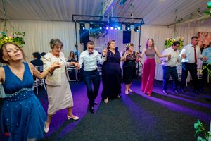 Dancers moving in sync at an indoor venue with atmospheric lighting and decorative elements.